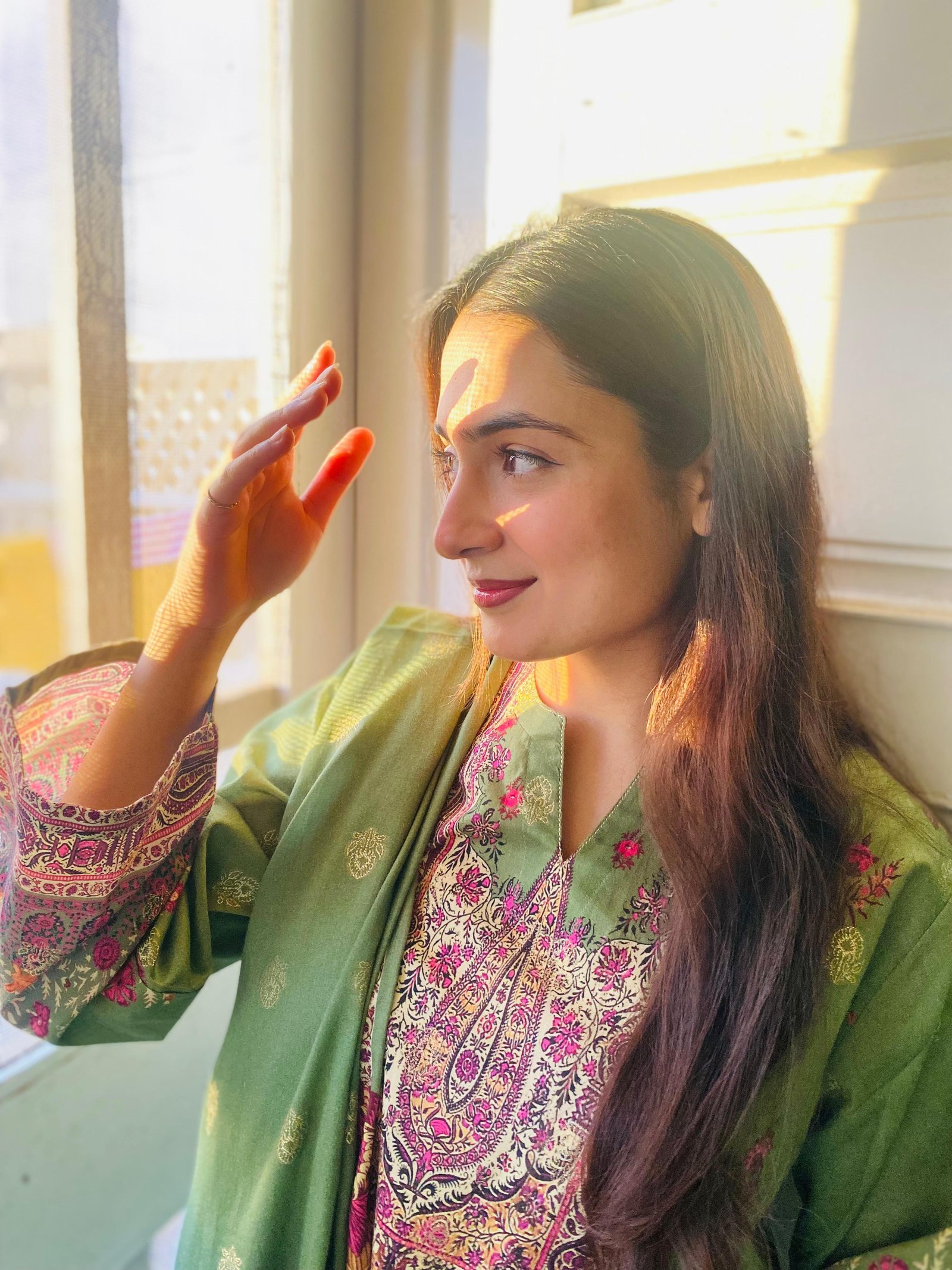 Ayesha beside a sunlit window