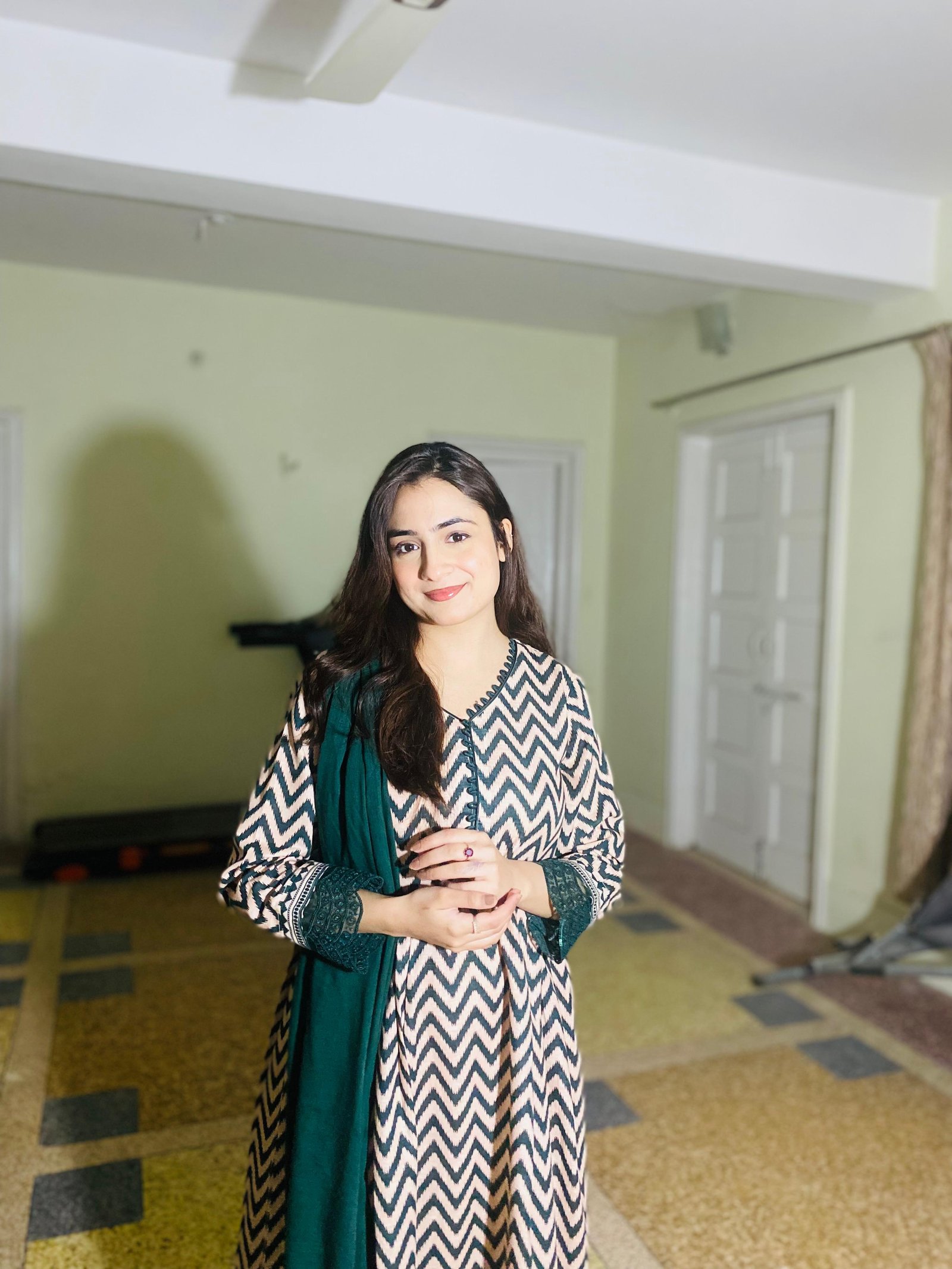 Ayesha smiling in a patterned outfit