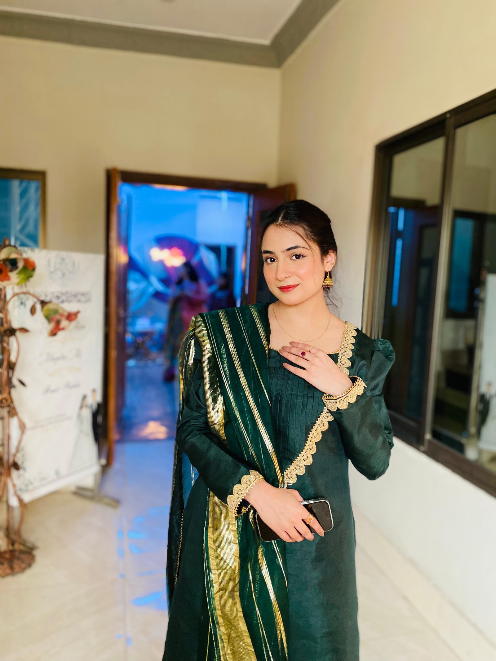 Ayesha in a dark green outfit with gold details
