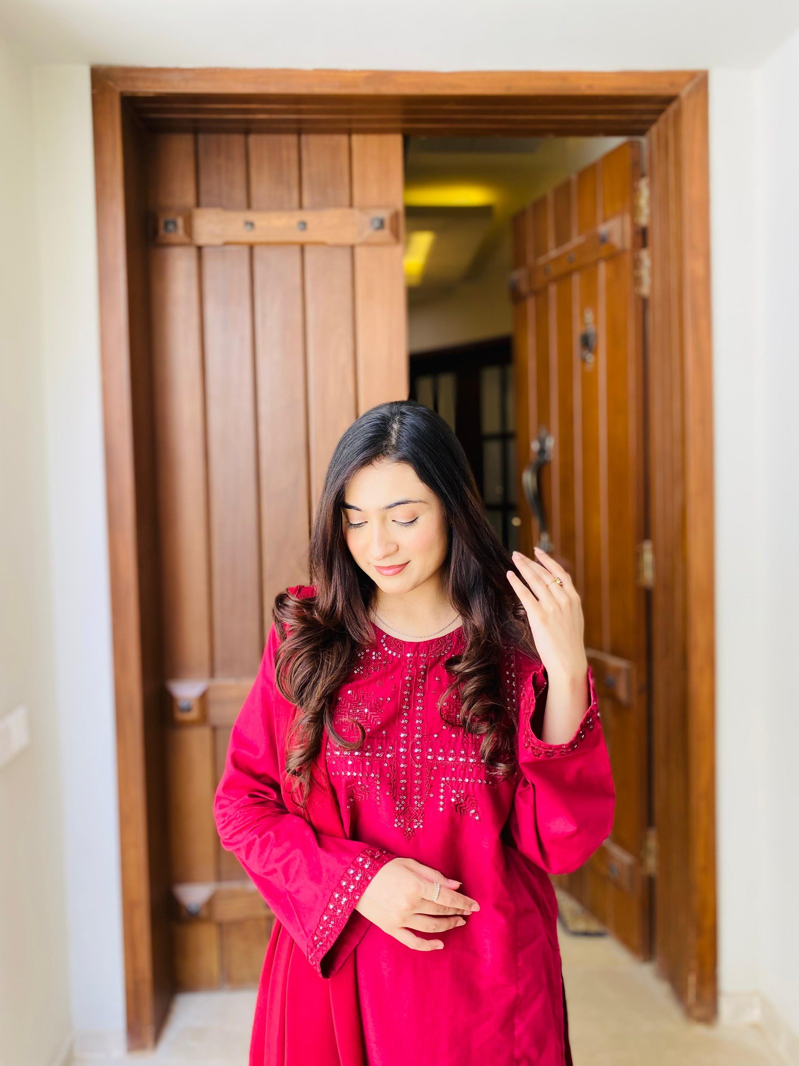 Ayesha in pink by a wooden doorway
