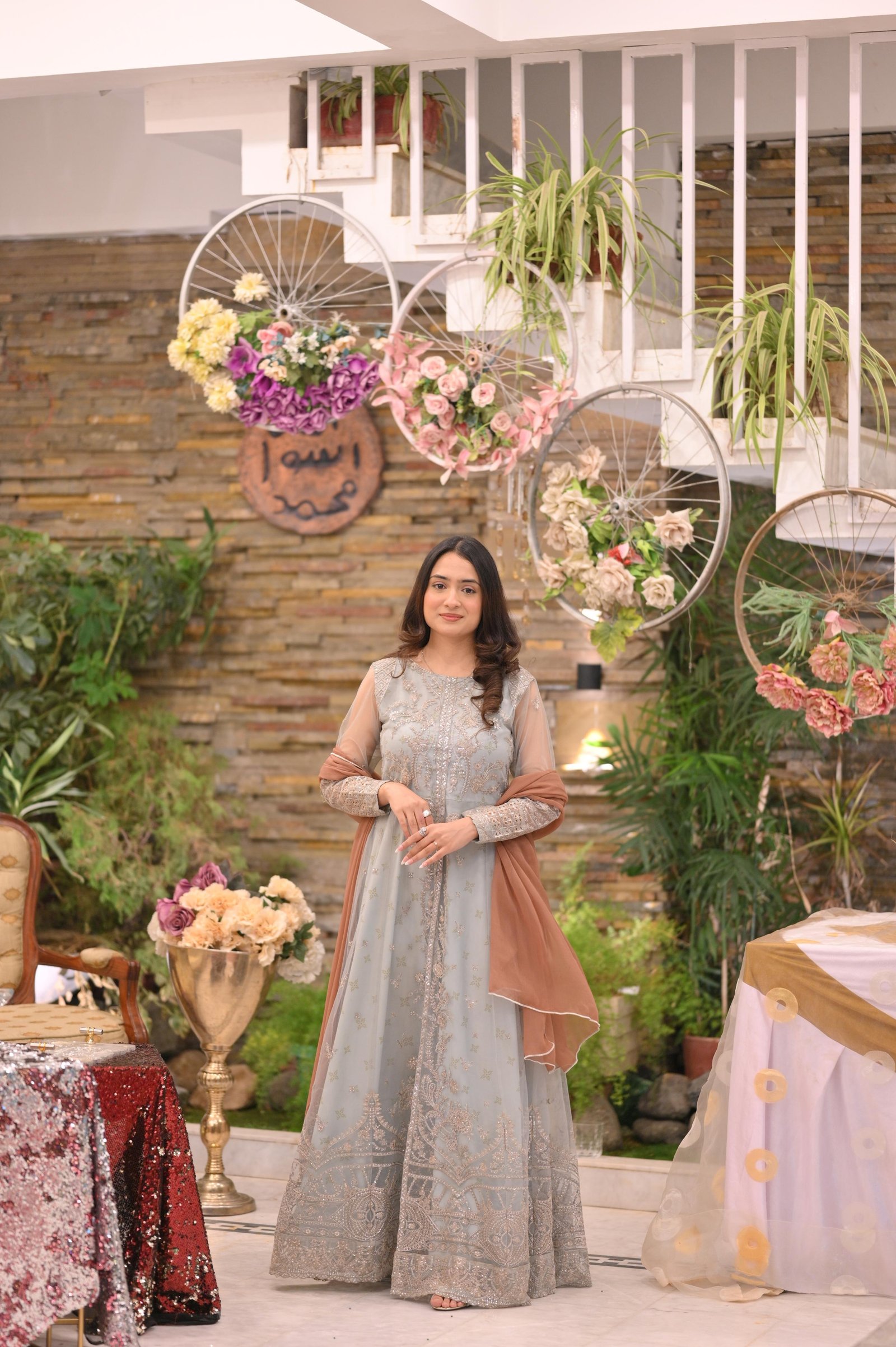 Ayesha in a silver outfit surrounded by flowers
