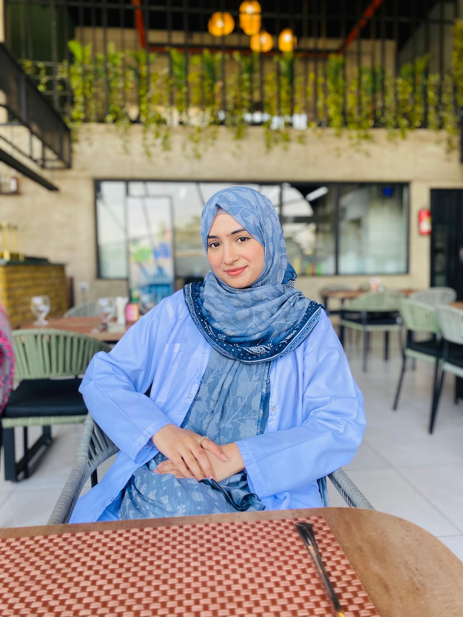 Ayesha smiling in blue at a café