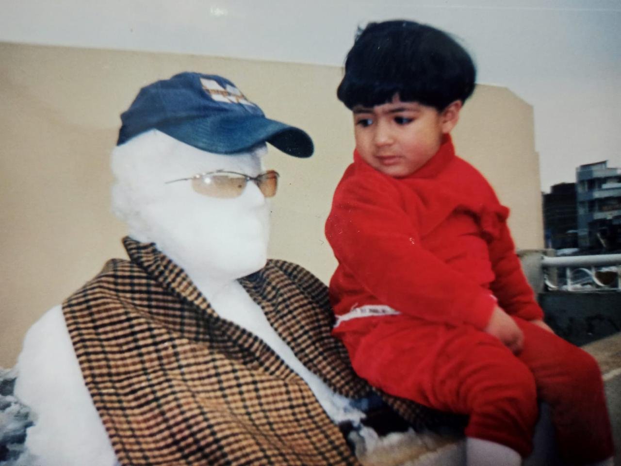 A childhood photograph beside a dressed-up figure