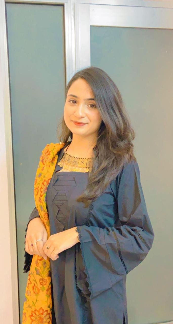 Ayesha in a dark outfit with a yellow floral scarf